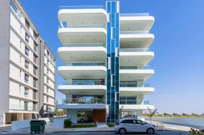 a building with a car parked in front of it at Aelia - Chic 2-BR Apartment & Balcony in Larnaca in Larnaka