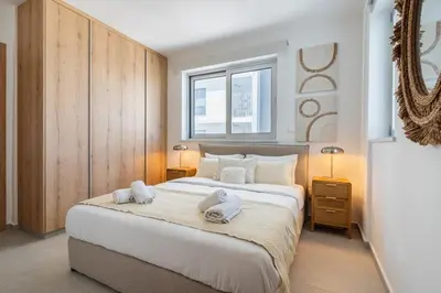 a bedroom with a large bed with towels on it at Aelia - Chic 2-BR Apartment & Balcony in Larnaca in Larnaka