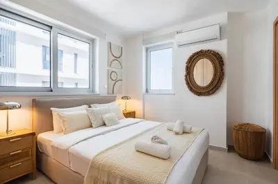a bedroom with a large bed with two towels on it at Aelia - Chic 2-BR Apartment & Balcony in Larnaca in Larnaka