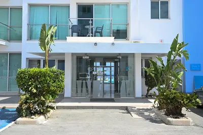 an apartment building with a glass door and palm trees at Crystal Coast in Protaras