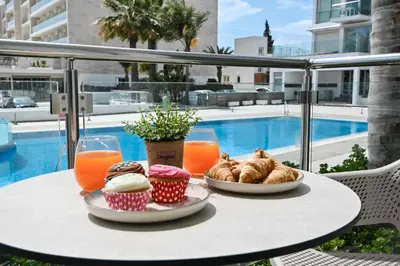 a table with pastries and orange juice and orange juice at Crystal Coast in Protaras