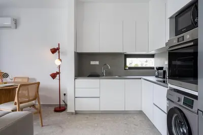 a white kitchen with a sink and a microwave at Solara - Stylish Balcony Apartments in Larnaca in Larnaka