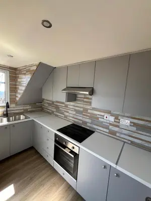 a kitchen with white cabinets and a stove top oven at Odou Residence in Odhou