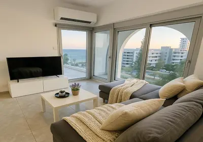 a living room with a couch and a flat screen tv at White Sea View Apartment in Limassol