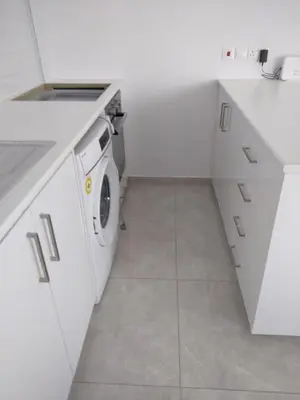 a white kitchen with a washing machine in it at White Sea View Apartment in Limassol