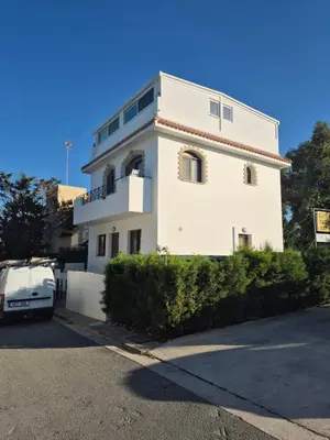 a white house with a car parked in front of it at Konnos Studio in Protaras