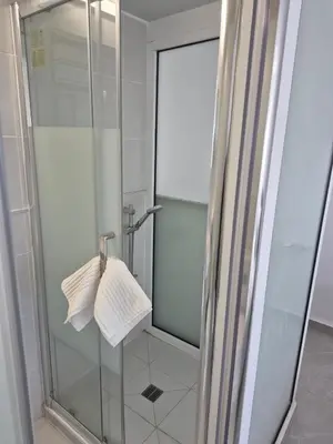 a shower with a glass door and a towel at Konnos Studio in Protaras