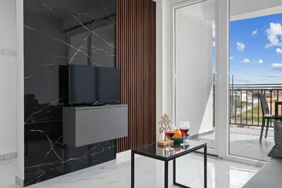a living room with a tv on a wall at Modern 2BR Apartment Near Ayia Napa - Anastasia 101 in Xylophaghou