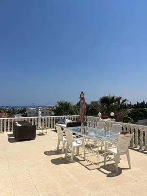 a glass table and white chairs on a patio at Huge Terrace in peaceful Oroklini in Voroklini