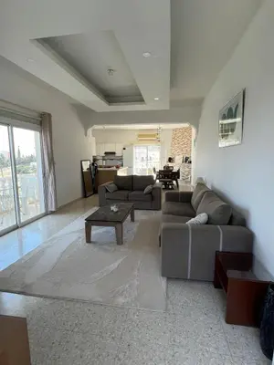 a living room with two couches and a table at Huge Terrace in peaceful Oroklini in Voroklini
