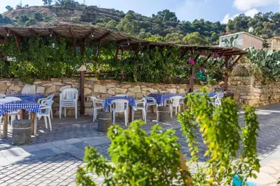 a patio with tables and chairs and a stone wall at Huge Terrace in peaceful Oroklini in Voroklini