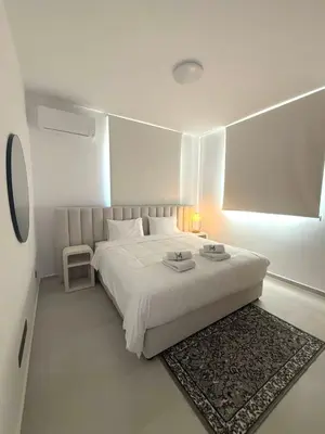 a white bedroom with a white bed and a rug at 201 Lux Suite Tower206 in Lakatamia