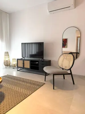 a living room with a chair and a television at 201 Lux Suite Tower206 in Lakatamia