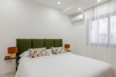 a white bedroom with a large bed with two pillows at Best location in Larnaca 100m from the beach in Larnaka