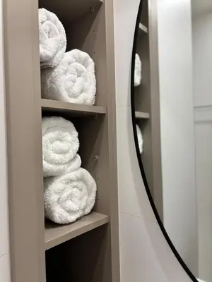 a pile of towels on a shelf in a bathroom at Best location in Larnaca 100m from the beach in Larnaka