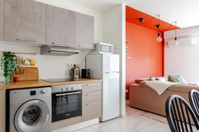 a kitchen with a refrigerator and a bed in a room at Best location in Larnaca 100m from the beach in Larnaka