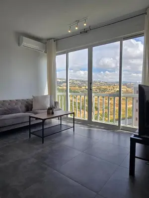 a living room with a couch and a large window at Studio by The Sea in Limassol