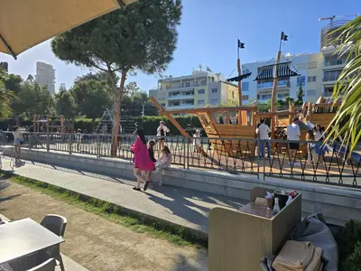 a woman and a child walking down a sidewalk at Studio by The Sea in Limassol