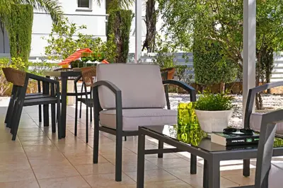 a group of chairs and tables on a patio at Villa GreenWay - Large Private Pool in Protaras