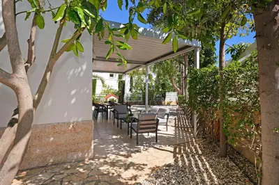 a patio with a table and chairs and trees at Villa GreenWay - Large Private Pool in Protaras