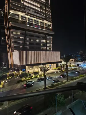 a tall building at night with cars in a parking lot at Takelena Apartments in Limassol