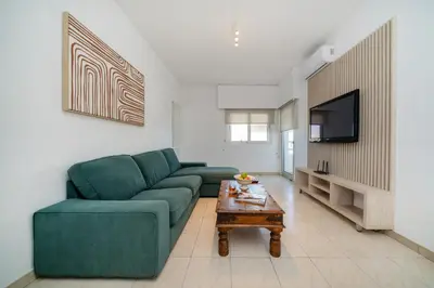 a living room with a green couch and a coffee table at Seafront central 1 bedroom flat in Limassol