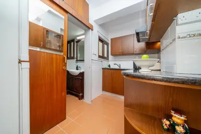 a kitchen with wooden cabinets and a counter top at Seafront central 1 bedroom flat in Limassol