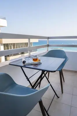 a table and chairs on a balcony with the ocean at Seafront central 1 bedroom flat in Limassol