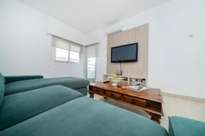 a bedroom with two green beds and a television at Seafront central 1 bedroom flat in Limassol