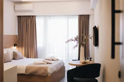 a bedroom with a bed and a table and a window at Kition Urban Suite 3 in Larnaka