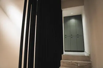 a hallway with black walls and a staircase with lockers at Kition Urban Suite 3 in Larnaka