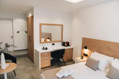 a bedroom with a bed and a desk and a mirror at Kition Urban Suite 3 in Larnaka