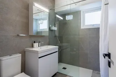 a bathroom with a toilet and a sink and a shower at Mackenzie Beach Apartment in Larnaka