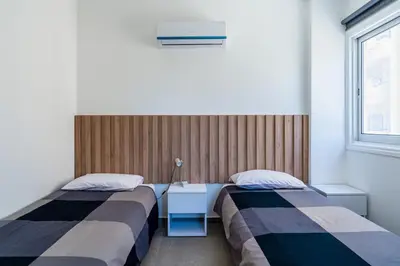 a room with two beds and a window at Mackenzie Beach Apartment in Larnaka