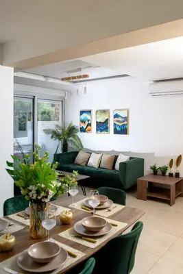 a living room with a table and a green couch at Green Island Apartment 102 in Larnaka