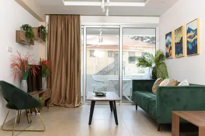 a living room with a green couch and a table at Green Island Apartment 102 in Larnaka