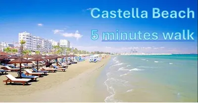 a beach with chairs and umbrellas and the ocean at Mackenzie By the sea one bed Ground floor home in Larnaka