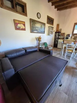 a living room with a large black leather couch at Cozy Paradise in Pedoulas