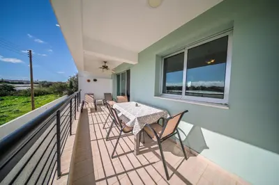 a patio with a table and chairs on a balcony at Chromata Lagoon Sea View Apartment in Paralimni