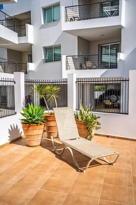 a chair on a patio in front of a building at Chromata Lagoon Sea View Apartment in Paralimni
