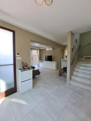 a large living room with a staircase and a couch at Villa Allamare with a pool in Paralimni