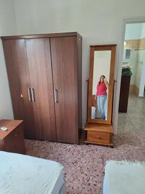 a woman standing in front of a mirror in a bedroom at Big house in center of protaras, near beach in Protaras