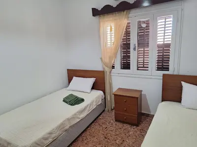 a bedroom with two twin beds and a window at Big house in center of protaras, near beach in Protaras