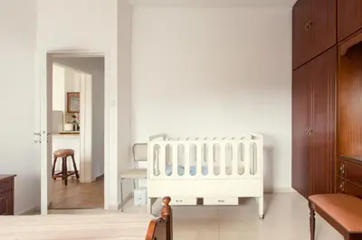 a bedroom with a white crib in a room at Spacious Larnaca Beach Apartment in Larnaka