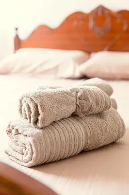 a pile of towels sitting on a bed at Spacious Larnaca Beach Apartment in Larnaka