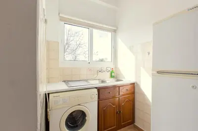 a bathroom with a washing machine and a sink at Spacious Larnaca Beach Apartment in Larnaka