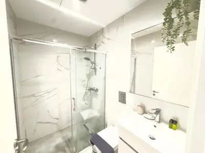 a white bathroom with a shower and a sink at Wealthystays Duplex in the Heart of Nicosia in Nicosia