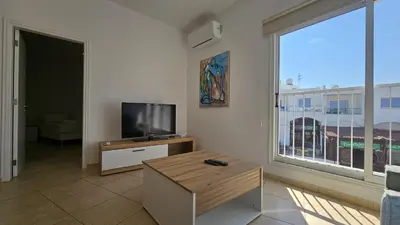 a living room with a tv and a large window at STAY Sunny Honey Apartment in Ayia Napa