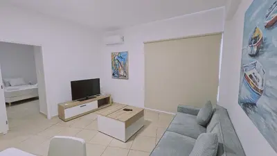 a living room with a couch and a tv at STAY Sunny Honey Apartment in Ayia Napa