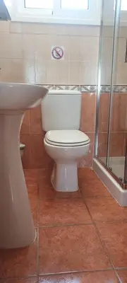 a bathroom with a white toilet and a sink at Sea Breeze Maisonette in Larnaka